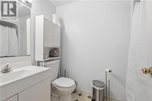Bathroom featuring a white vanity with integrated sink, chrome faucet, wall-mounted mirror, and white over-the-toilet storage cabinetry - 292 Mayview Court Unit# B, Waterloo, ON - Indoor Photo Showing Bathroom