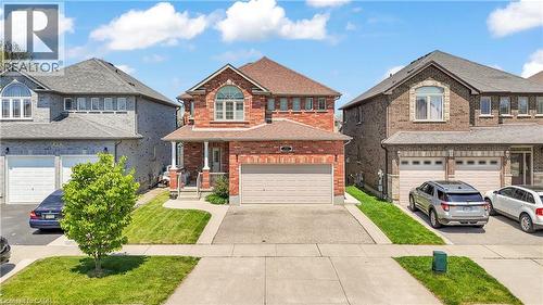 Two-story brick exterior featuring a covered porch, an arched window, and a single-car garage - 73 Fitzgerald Drive, Cambridge, ON - Outdoor With Facade