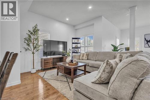 Open-concept living area featuring hardwood flooring, white walls, recessed lighting, and plantation shutters - 73 Fitzgerald Drive, Cambridge, ON - Indoor Photo Showing Living Room