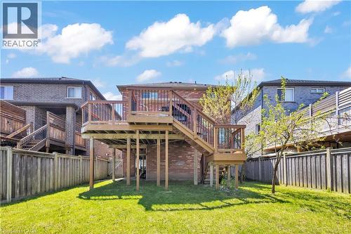 Elevated wood deck with baluster railings and staircase, brick exterior, and a spacious green lawn - 73 Fitzgerald Drive, Cambridge, ON - Outdoor With Deck Patio Veranda