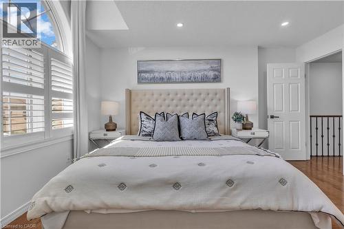 Bedroom featuring an arched window, plantation shutters, recessed lighting, wood-finish flooring, and a six-panel door with matte black hardware - 73 Fitzgerald Drive, Cambridge, ON - Indoor Photo Showing Bedroom