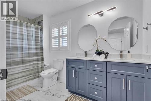 Bathroom featuring a double vanity with blue cabinetry, dual octagonal mirrors, and a white countertop - 73 Fitzgerald Drive, Cambridge, ON - Indoor Photo Showing Bathroom