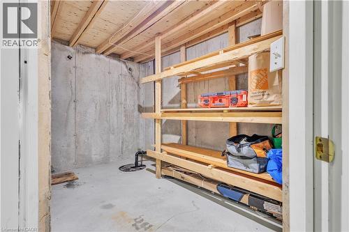 Utility space featuring exposed concrete walls and ceiling joists, concrete flooring, and built-in wooden shelving for storage - 73 Fitzgerald Drive, Cambridge, ON - Indoor