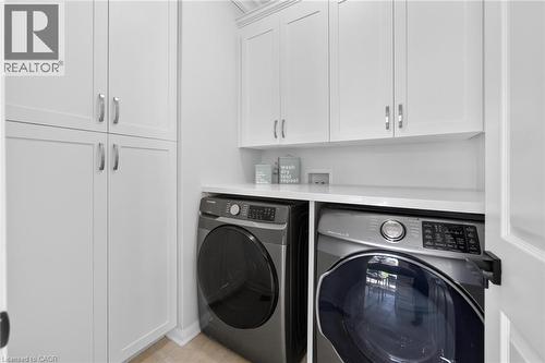 Laundry area featuring white shaker-style cabinetry, a built-in countertop, and neutral flooring - 1533 Morse Place, Milton, ON - Indoor Photo Showing Laundry Room