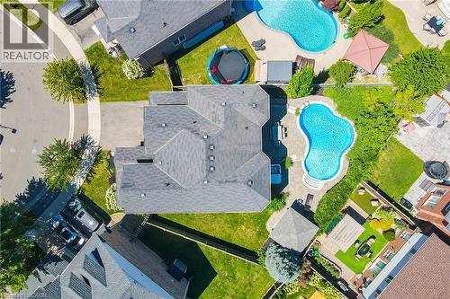 Curved inground pool with surrounding hardscaping and a stone patio - 1533 Morse Place, Milton, ON - Outdoor With In Ground Pool With View