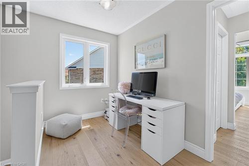 Bright interior space featuring light wood-finish flooring, a double window with white trim, and a white balustrade - 1533 Morse Place, Milton, ON - Indoor Photo Showing Office