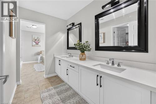 Dual vanity featuring white shaker-style cabinetry, chrome fixtures, and a light-toned countertop - 1533 Morse Place, Milton, ON - Indoor Photo Showing Bathroom
