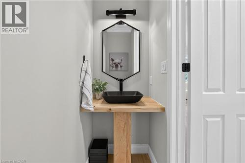 Modern vanity featuring a natural wood-finish countertop, a black vessel sink, and a matte black wall-mounted faucet - 1533 Morse Place, Milton, ON - Indoor Photo Showing Other Room