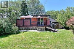 Backyard featuring a wood deck with a lattice skirt, privacy screens, and an attached pergola - 