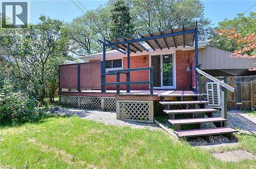 Rear deck featuring a pergola, lattice skirting, and direct access to the interior via a sliding glass door - 245 West 33Rd Street, Hamilton, ON - Outdoor With Deck Patio Veranda
