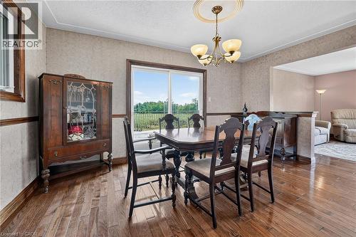 Dining area featuring wood-finish flooring, a decorative chandelier, and a sliding glass door to the exterior - 134 Russ Road, Grimsby, ON - Indoor Photo Showing Dining Room