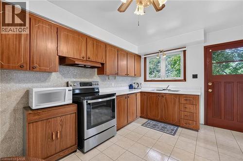 Kitchen featuring wood-finish cabinetry, white countertops, and tile flooring - 134 Russ Road, Grimsby, ON - Indoor Photo Showing Kitchen