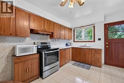 Kitchen featuring wood-finish cabinetry, white countertops, and tile flooring - 