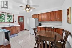 Kitchen featuring wood-finish cabinetry, light-toned countertops, and a tile floor - 