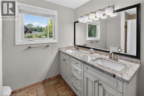 Double vanity featuring undermount sinks, stone countertops, and brushed nickel fixtures - 134 Russ Road, Grimsby, ON - Indoor Photo Showing Bathroom