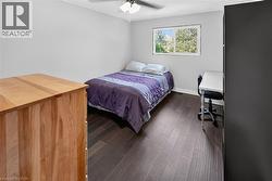 Room featuring dark wood-finish flooring, light grey walls, and a ceiling fan with integrated lighting - 
