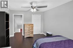 Interior room featuring dark wood-finish flooring, light grey walls, and white baseboards - 