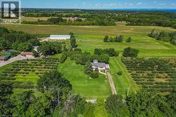 Expansive property featuring a single-story residence, a large outbuilding, and significant cultivated land - 