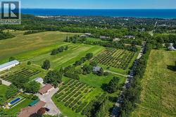 Expansive property featuring structured orchards, multiple buildings including a residential structure and outbuildings, and paved access roads - 