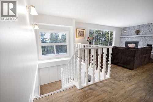 Main floor entrance, stairs to basement. Large beautiful window above stairs with ample storage under window. - 2527 Islandview Road, Blind Bay, BC - Indoor Photo Showing Other Room With Fireplace