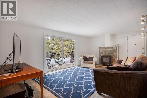 Rec. room with fireplace and patio doors to back yard & hot tub. - 2527 Islandview Road, Blind Bay, BC - Indoor With Fireplace