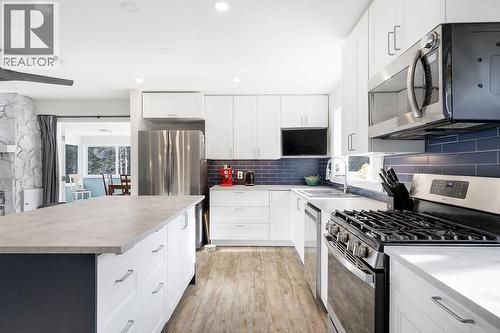Renovated Kitchen, stainless steal appliances and large island that faces the living room. Views from the front and back of house. - 2527 Islandview Road, Blind Bay, BC - Indoor Photo Showing Kitchen With Double Sink With Upgraded Kitchen