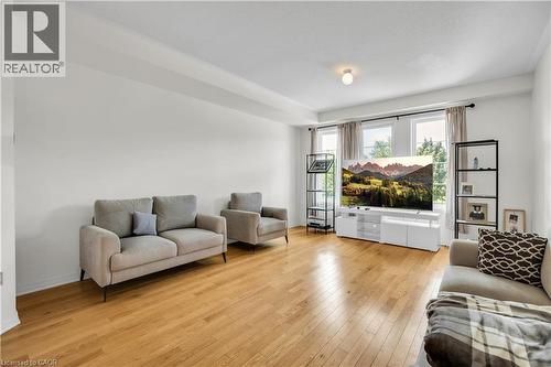 Spacious living area featuring wood-finish flooring, white walls, and multiple windows with curtain rods - 1451 Green Road, Bowmanville, ON - Indoor Photo Showing Living Room