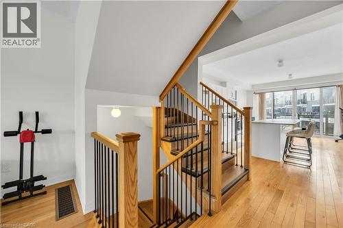 Hardwood staircase with natural wood handrails and black metal balusters - 1451 Green Road, Bowmanville, ON - Indoor Photo Showing Other Room