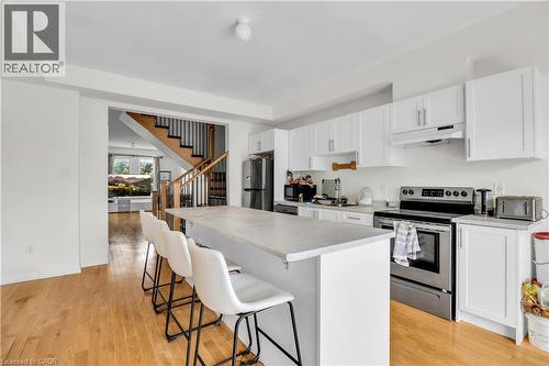 Modern kitchen featuring white cabinetry, stainless steel appliances, and a central island with a light-toned countertop - 1451 Green Road, Bowmanville, ON - Indoor Photo Showing Kitchen
