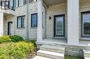 Light brick facade with dark-framed windows and a covered entrance featuring a glass-paneled door - 1451 Green Road, Bowmanville, ON  - Outdoor 