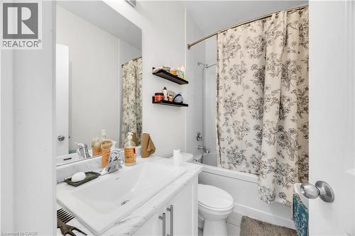 Bathroom featuring a white vanity with an integrated sink, a rectangular mirror, and a white bathtub with a shower fixture - 1451 Green Road, Bowmanville, ON - Indoor Photo Showing Bathroom