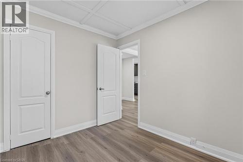 Neutral wall paint with crown molding and wood-finish flooring - 36 Mahony Avenue, Hamilton, ON - Indoor Photo Showing Other Room