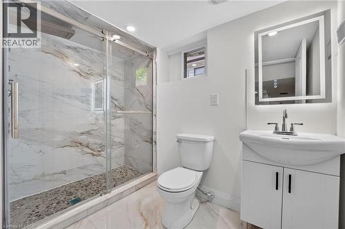 Contemporary bathroom featuring a spacious glass-enclosed shower with marble-patterned tile walls and a pebble-stone floor - 36 Mahony Avenue, Hamilton, ON - Indoor Photo Showing Bathroom