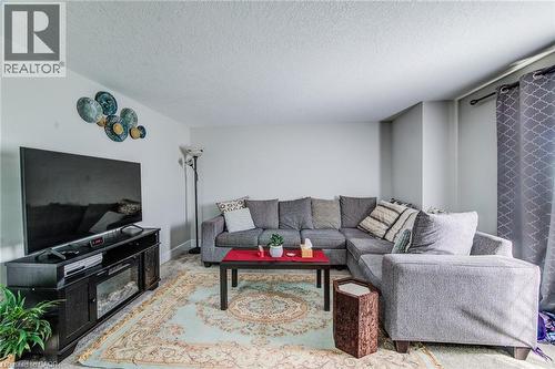Bright living area featuring light-colored walls and a textured ceiling - 233 Red Clover Court, Kitchener, ON - Indoor Photo Showing Living Room