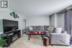 Bright living area featuring light-colored walls and a textured ceiling - 