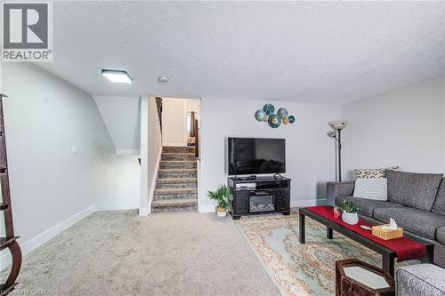 Carpeted living space with white walls and a textured ceiling - 233 Red Clover Court, Kitchener, ON - Indoor Photo Showing Living Room