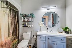 Bathroom vanity with a white countertop, undermount sink, and light gray cabinetry - 