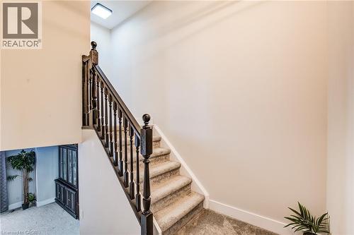 Carpeted staircase with dark wood newel posts and spindles - 233 Red Clover Court, Kitchener, ON - Indoor Photo Showing Other Room
