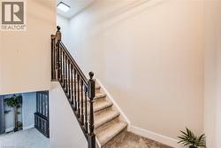 Carpeted staircase with dark wood newel posts and spindles - 