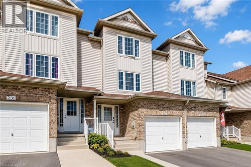 Multi-level townhome exterior featuring light-toned siding and brick accents - 233 Red Clover Court, Kitchener, ON - Outdoor With Facade