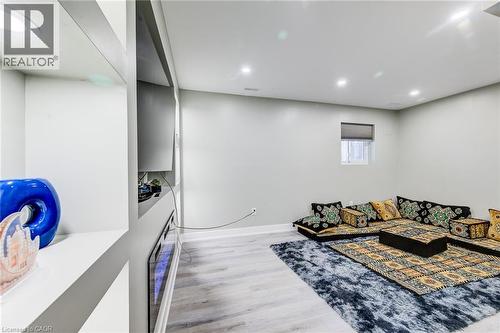 Recessed lighting illuminates this room, featuring wood-finish flooring and a built-in shelving unit - 233 Red Clover Court, Kitchener, ON - Indoor