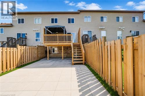 Expansive backyard oasis featuring a composite patio with linear inset detailing, newly constructed pressure-treated wood privacy fencing, and an elevated composite deck with integrated staircase and - 233 Red Clover Court, Kitchener, ON - Outdoor With Deck Patio Veranda With Exterior