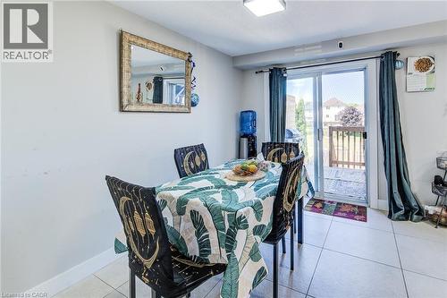 Dining area featuring light tile flooring and a patio door leading to a wooden deck - 233 Red Clover Court, Kitchener, ON - Indoor Photo Showing Dining Room
