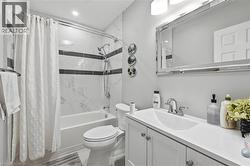 Full bathroom featuring a white vanity with integrated sink, chrome faucet, and framed mirror - 