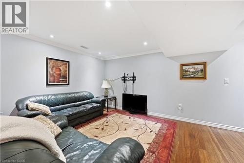 Spacious recreation room featuring recessed lighting, crown molding, wood-finish flooring, and light-toned walls - 10 Kopperfield Lane, Hamilton, ON - Indoor