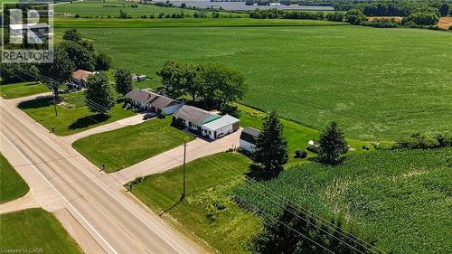 Property with two structures featuring light-colored siding and a green metal roof, set on a manicured lawn - 184726 Cornell Road, Tillsonburg, ON - Outdoor With View