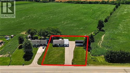 Aerial property view featuring a main residence, an outbuilding, and expansive cultivated fields - 184726 Cornell Road, Tillsonburg, ON - Outdoor