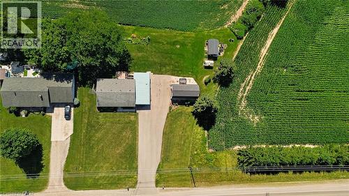 Aerial property overview featuring two residential structures, extensive green space, and a large cultivated field - 184726 Cornell Road, Tillsonburg, ON - Outdoor With View