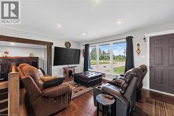 Spacious room featuring wood-finish flooring, recessed lighting, and a prominent window offering exterior views - 