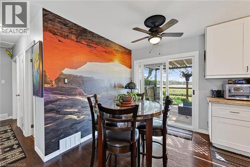 Dining area featuring a full-wall mural, wood-finish flooring, and a ceiling fan with integrated lighting - 184726 Cornell Road, Tillsonburg, ON - Indoor Photo Showing Dining Room